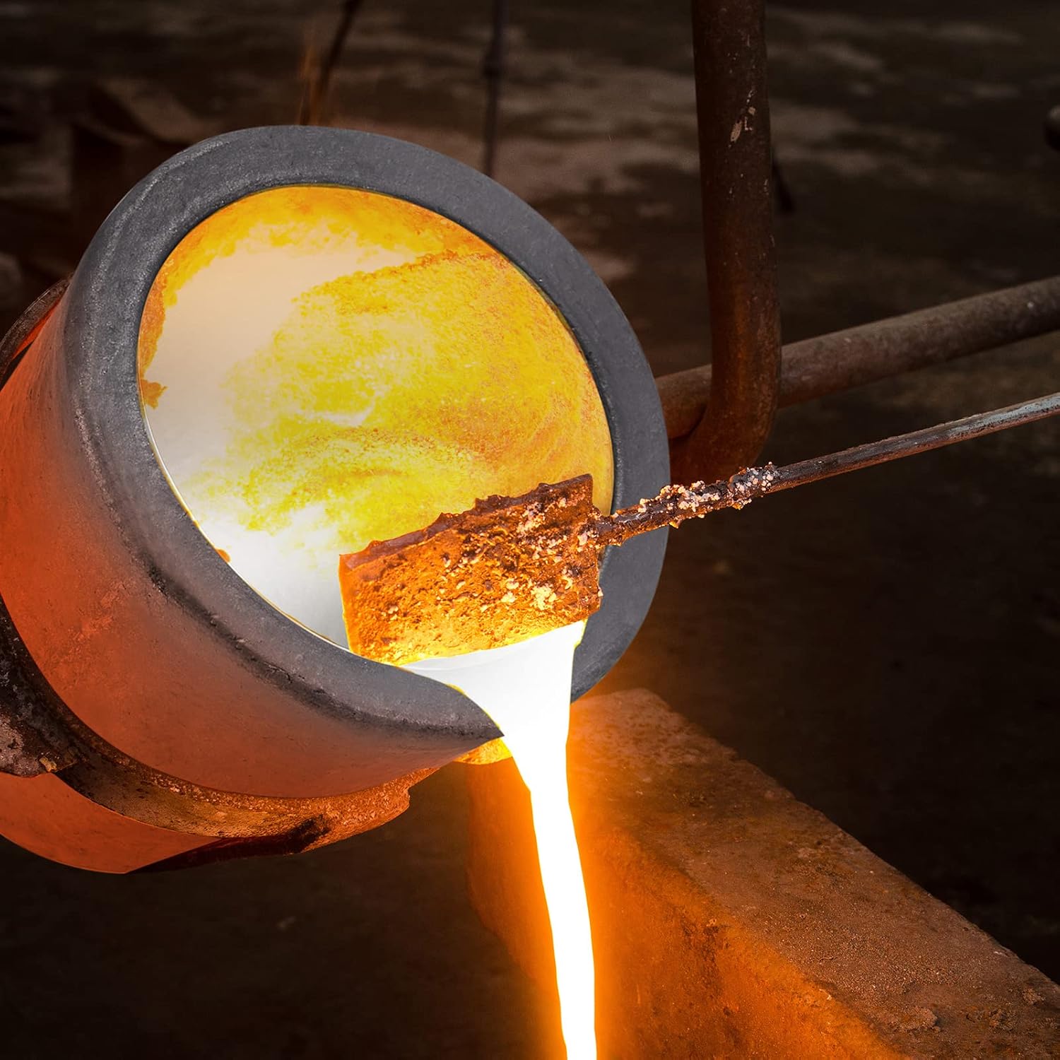 Molten gold being poured from a glowing crucible into a mold, showing the metal refining and jewelry casting process.